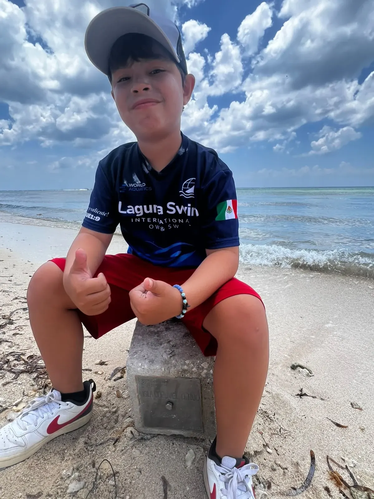 Un nadador del equipo con la playera de Laguna Swim en la playa de Cozumel